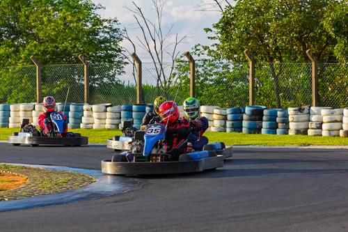 Pilotos disputando uma curva no Kart Veloce